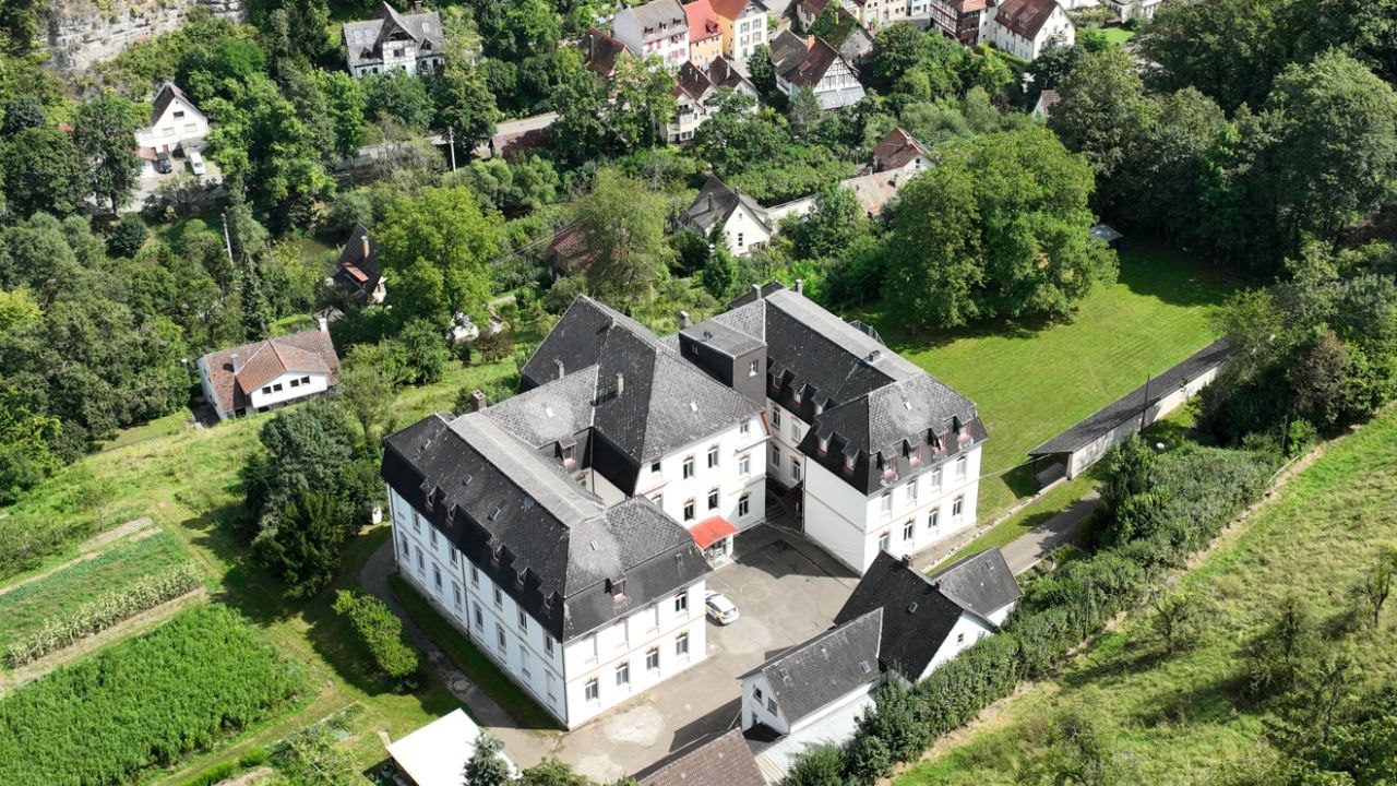 Das Missionshaus von oben, eingebettet zwischen Gärten und Häusern